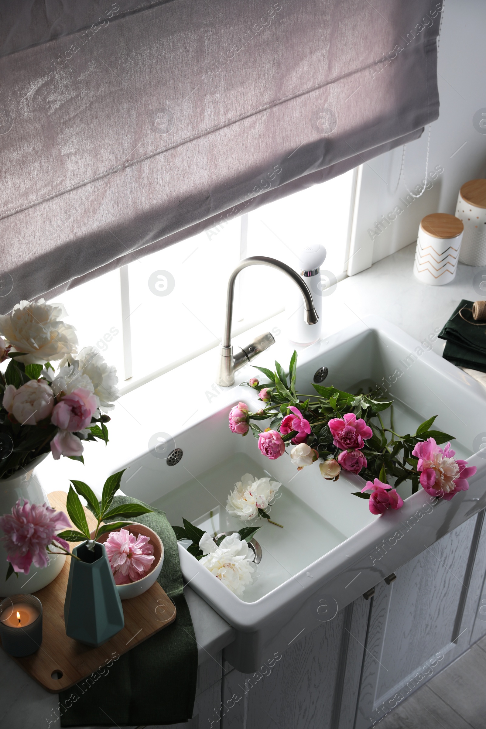 Photo of Beautiful kitchen counter design with fresh peonies