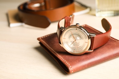 Luxury wrist watch and wallet on wooden background, closeup