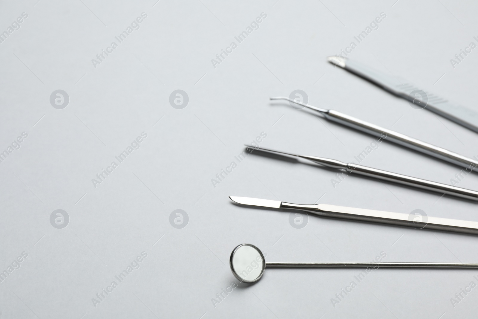 Photo of Set of different dentist's tools on light grey background. Space for text