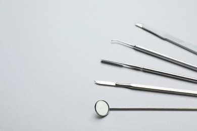 Set of different dentist's tools on light grey background. Space for text