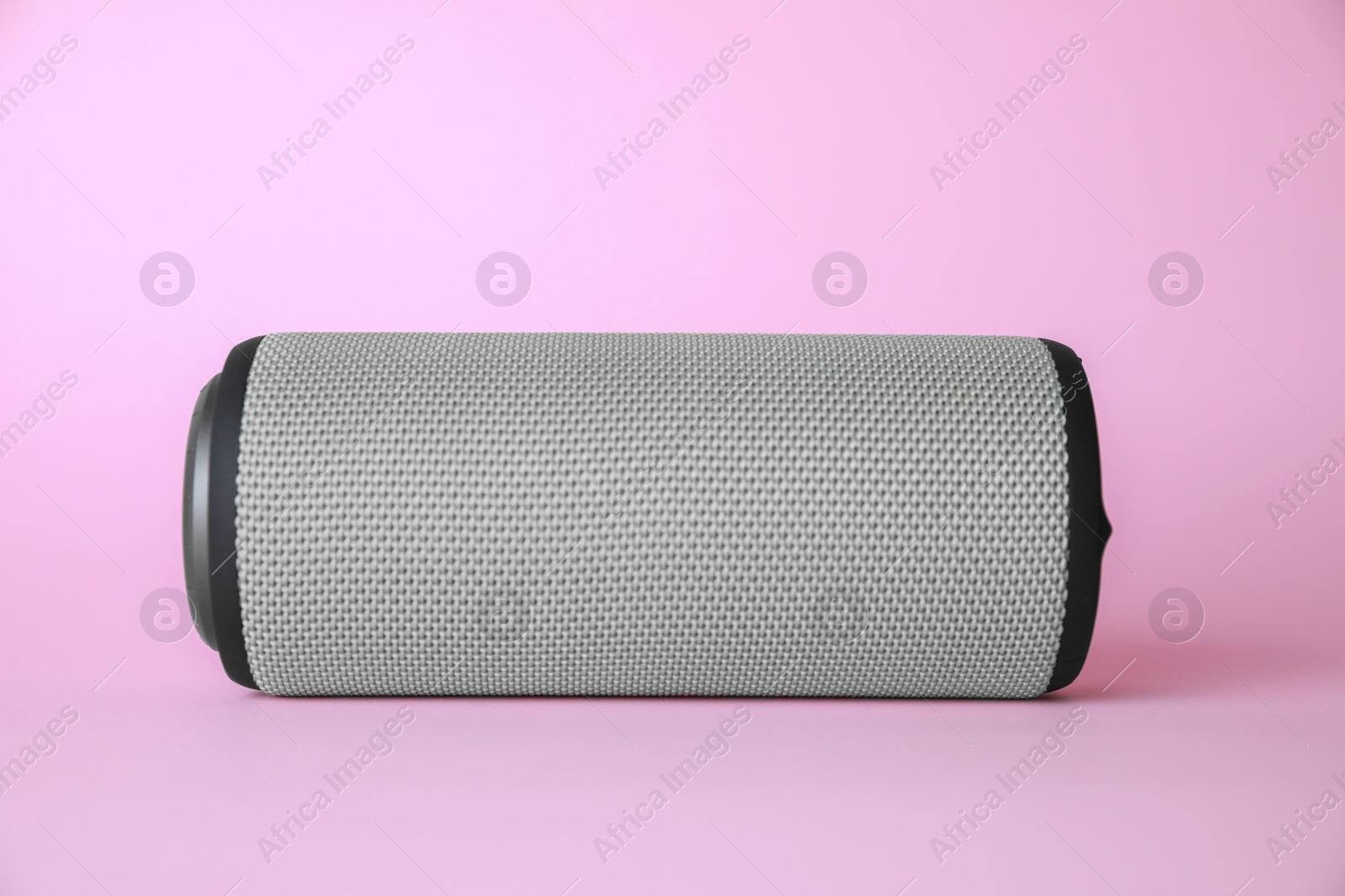 Photo of One portable bluetooth speaker on pink background. Audio equipment