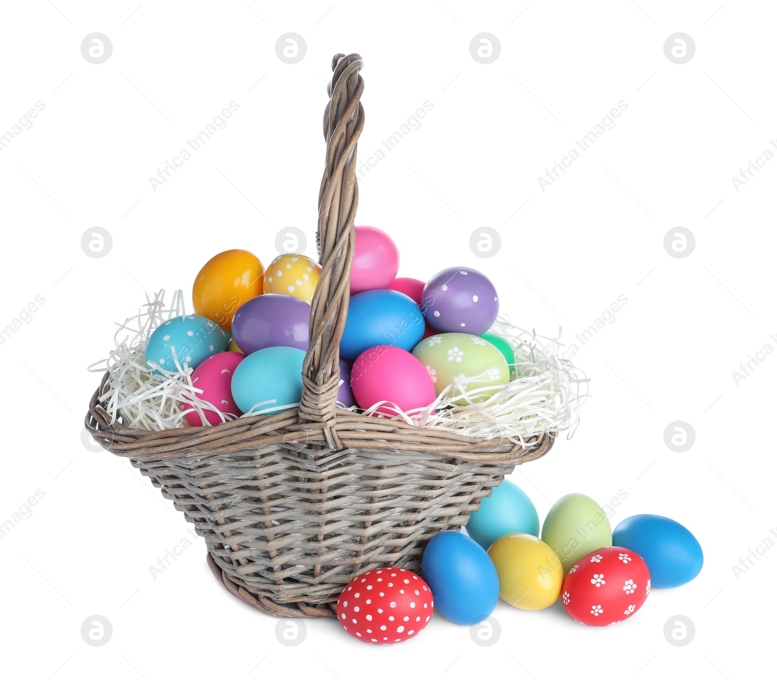 Photo of Wicker basket with bright painted Easter eggs on white background