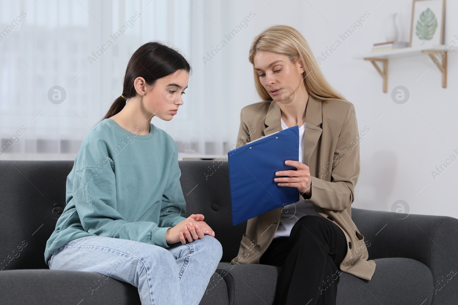 Photo of Psychologist working with teenage girl in office. Teenager problems