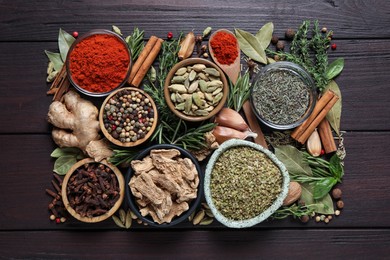 Photo of Different natural spices and herbs on wooden table, flat lay