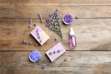 Photo of Flat lay composition of handmade soap bars with lavender flowers and ingredients on brown wooden background