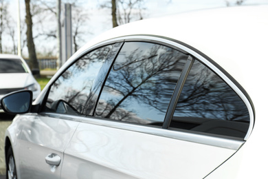 Photo of Modern car with tinting foil on window outdoors, closeup