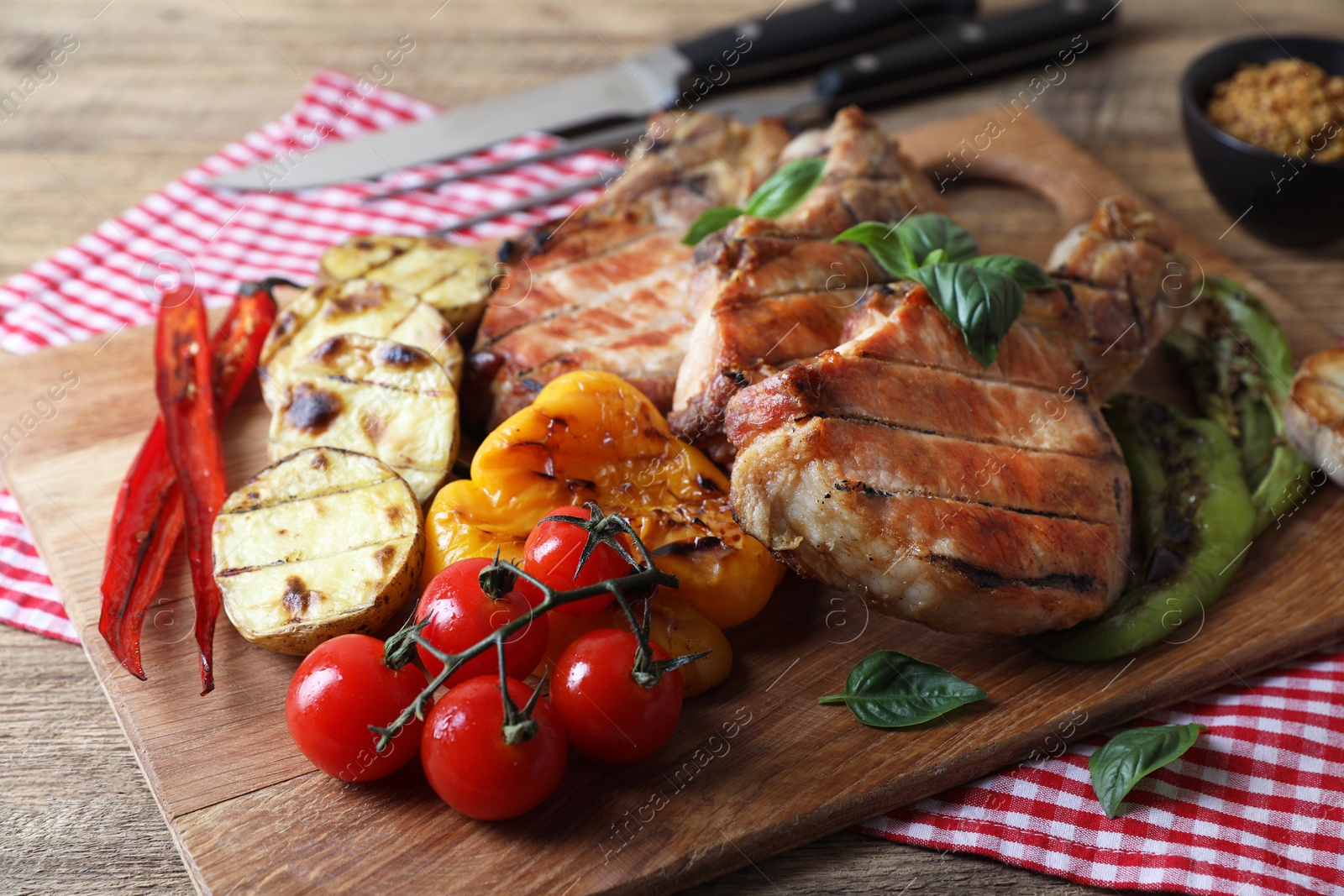 Photo of Delicious grilled meat and vegetables served on wooden table, closeup