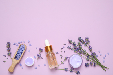 Flat lay composition with lavender flowers and natural cosmetic products on pink background. Space for text