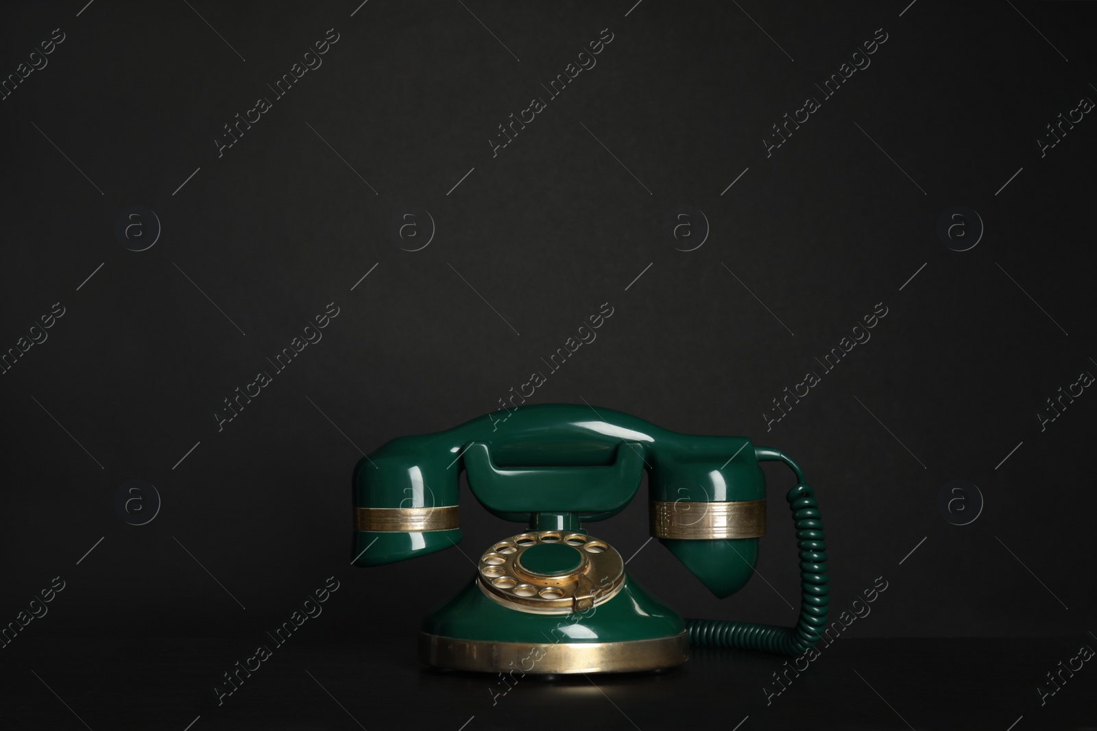 Photo of Green vintage corded phone on black table