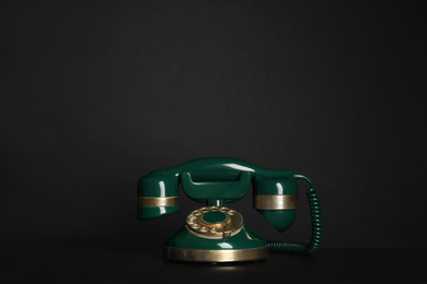 Photo of Green vintage corded phone on black table