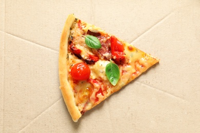 Last slice of tasty pizza with tomatoes and sausages in cardboard box, top view