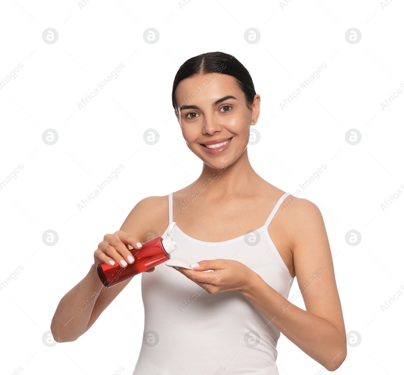 Photo of Young woman pouring micellar water onto cotton pad on white background