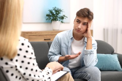 Psychologist working with teenage boy in office