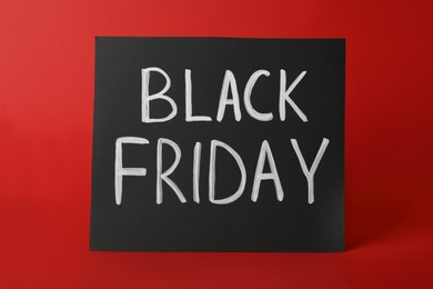 Photo of Card with phrase Black Friday on red background
