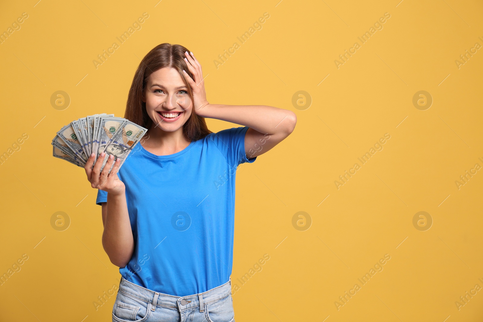 Photo of Portrait of happy lottery winner with money on yellow background, space for text