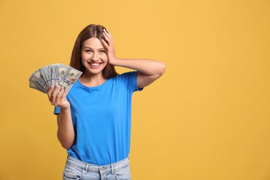 Portrait of happy lottery winner with money on yellow background, space for text