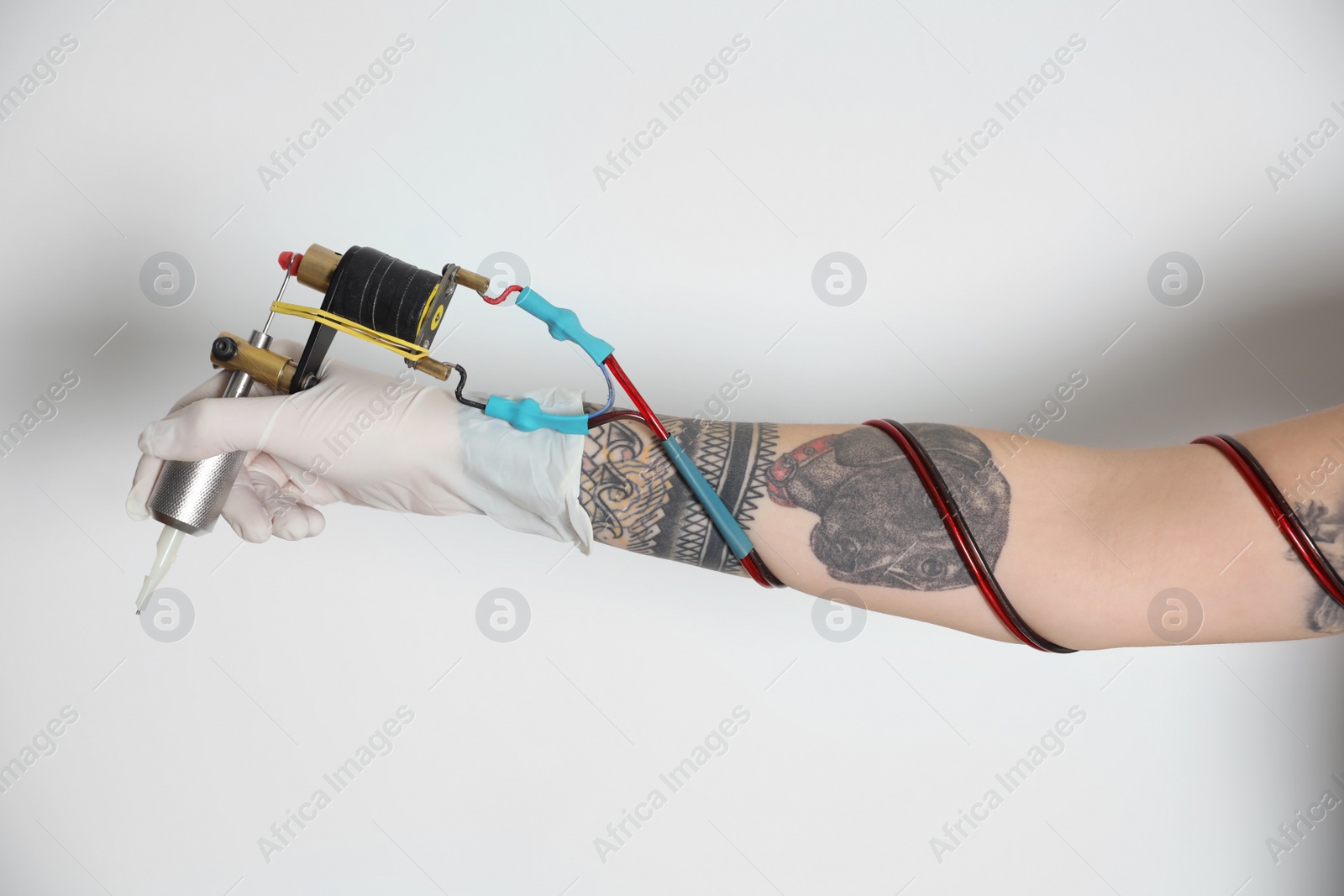 Photo of Tattoo artist with professional machine on white background, closeup