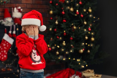 Photo of Little child closing his eyes with hands at home, space for text. Christmas celebration