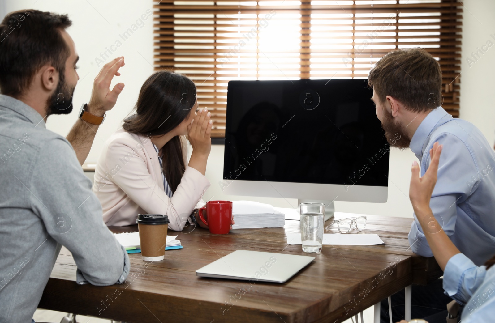 Photo of Group of colleagues using video chat on computer in office. Space for text