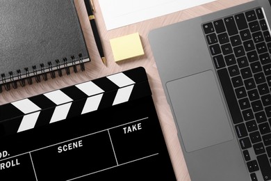 Flat lay composition with movie clapper on wooden table