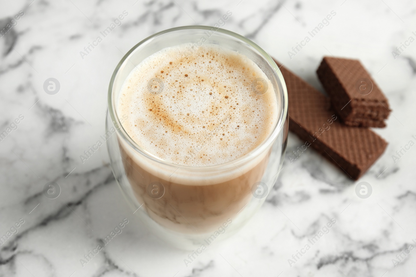 Photo of Delicious coffee and wafers for breakfast on white marble table