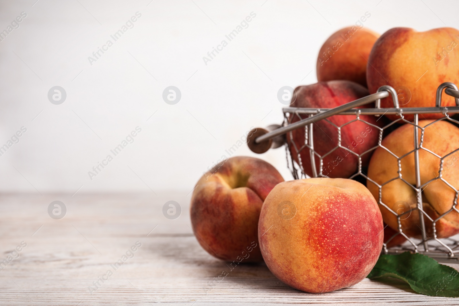 Photo of Fresh ripe juicy peaches on white wooden table, closeup. Space for text