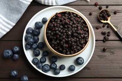 Photo of Freeze dried and fresh blueberries on wooden table, flat lay