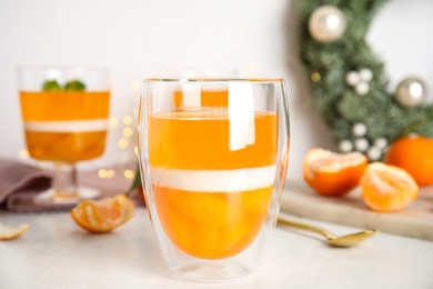 Photo of Delicious tangerine jelly in glass on white table