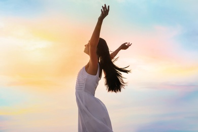 Young woman enjoying summer day against sky. Freedom of zen