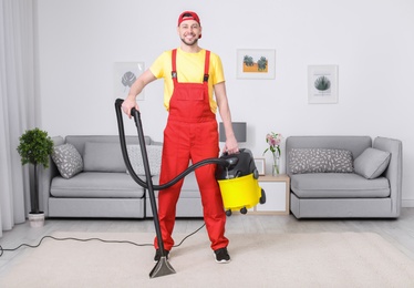 Mature man hoovering carpet with vacuum cleaner in living room