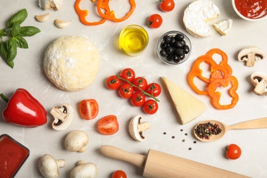 Flat lay composition pizza dough and fresh ingredients on marble table