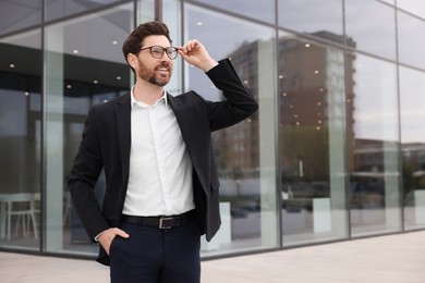 Happy real estate agent outdoors. Space for text