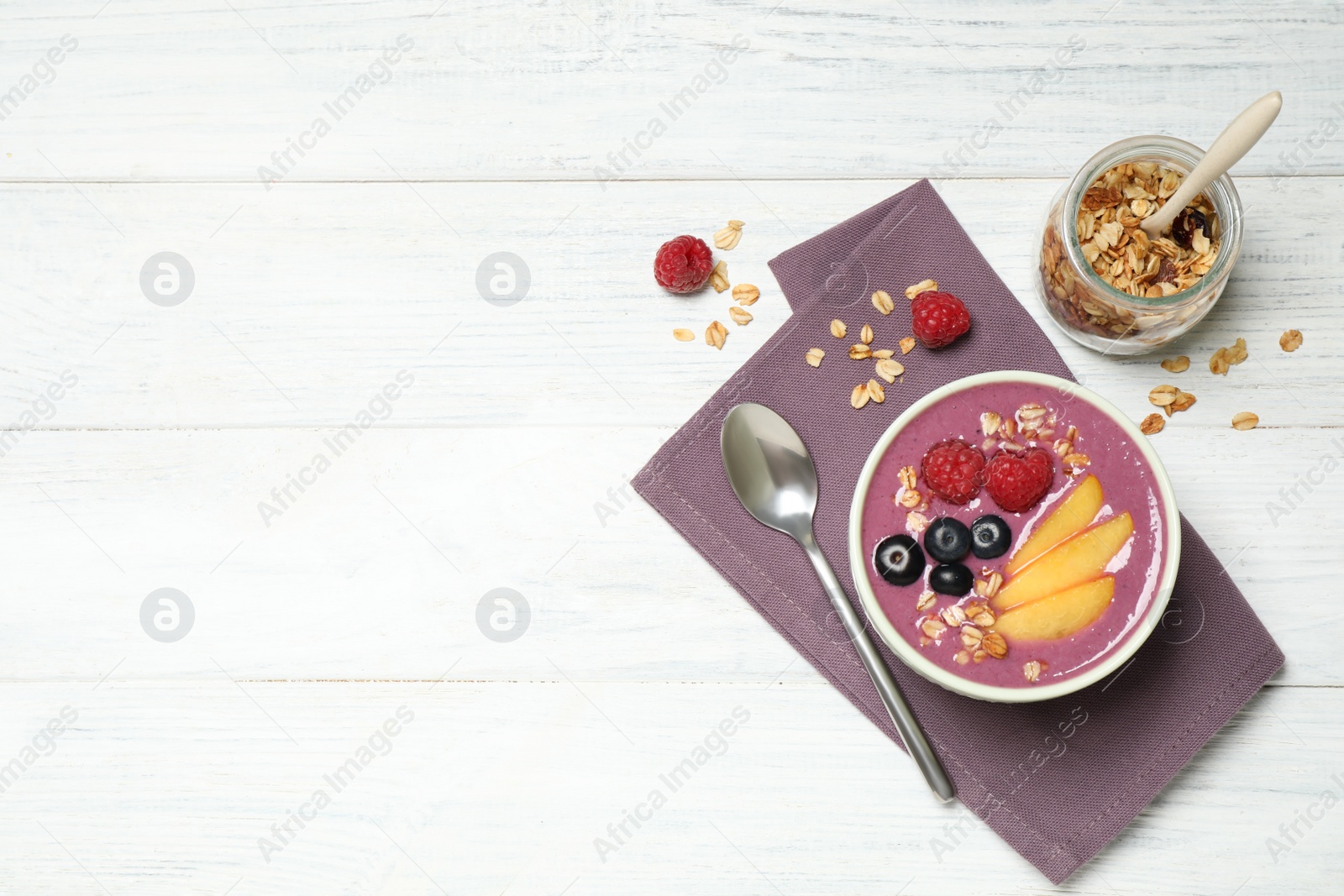 Photo of Delicious acai smoothie served on white wooden table, flat lay. Space for text