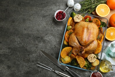 Delicious chicken with oranges and vegetables on grey table, flat lay. Space for text