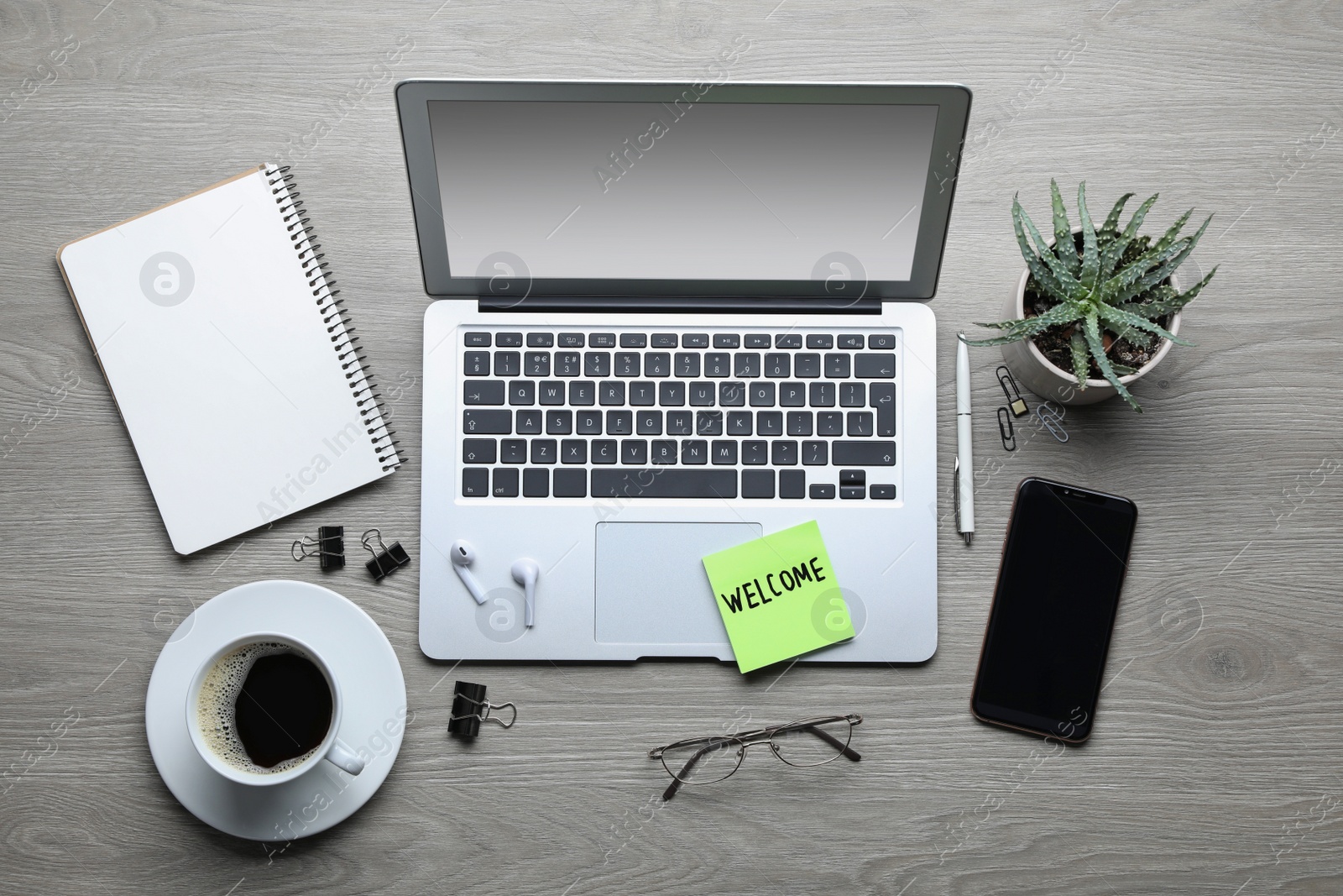 Photo of Flat lay composition of note with word Welcome and gadgets on wooden table