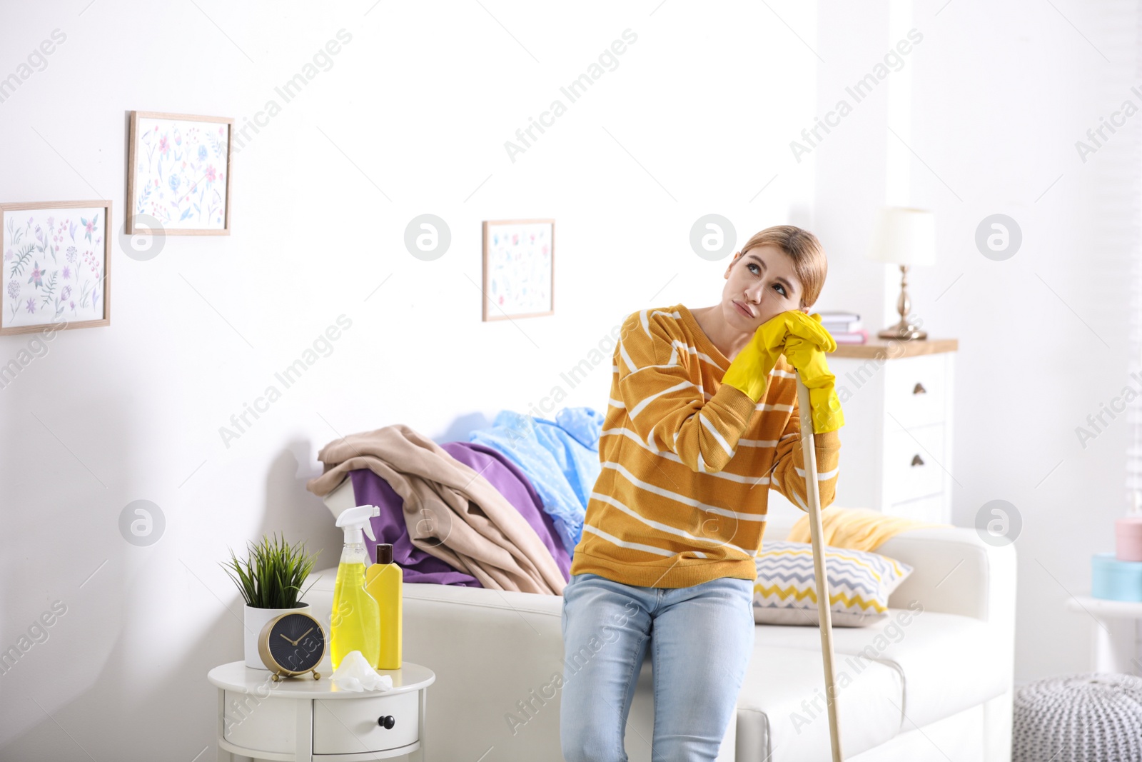 Photo of Lazy young woman with mop at home. Cleaning and housework