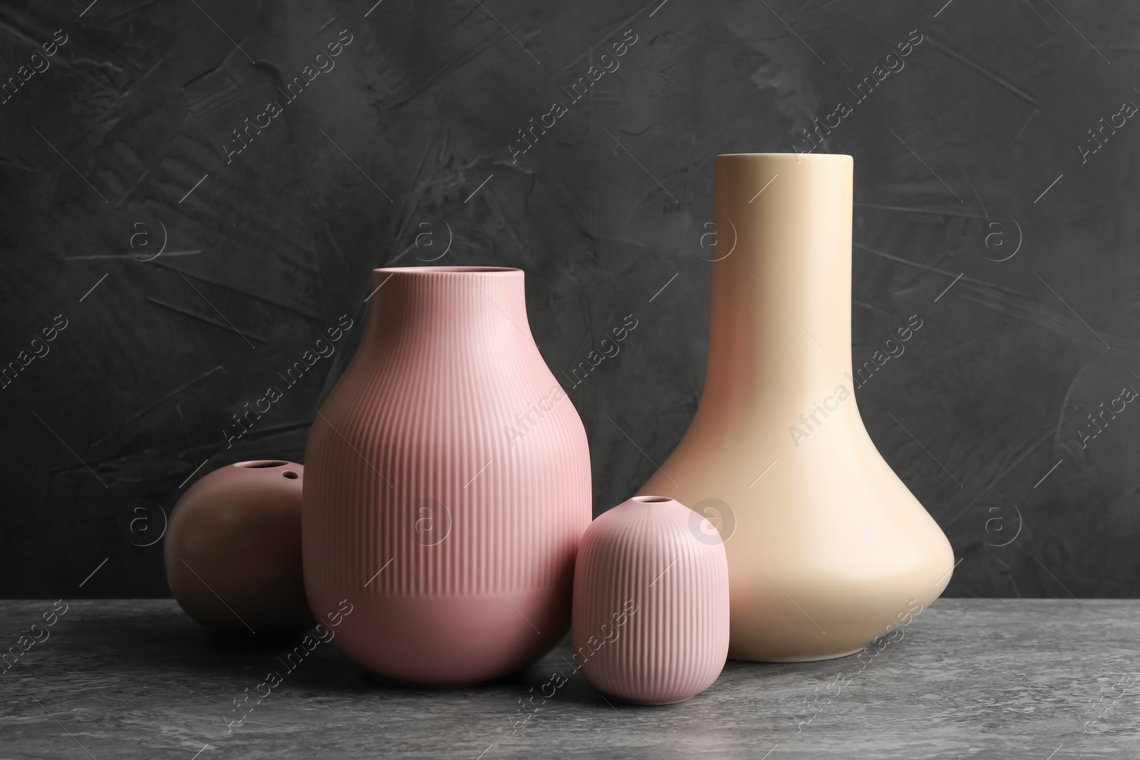 Photo of Stylish empty ceramic vases on grey table