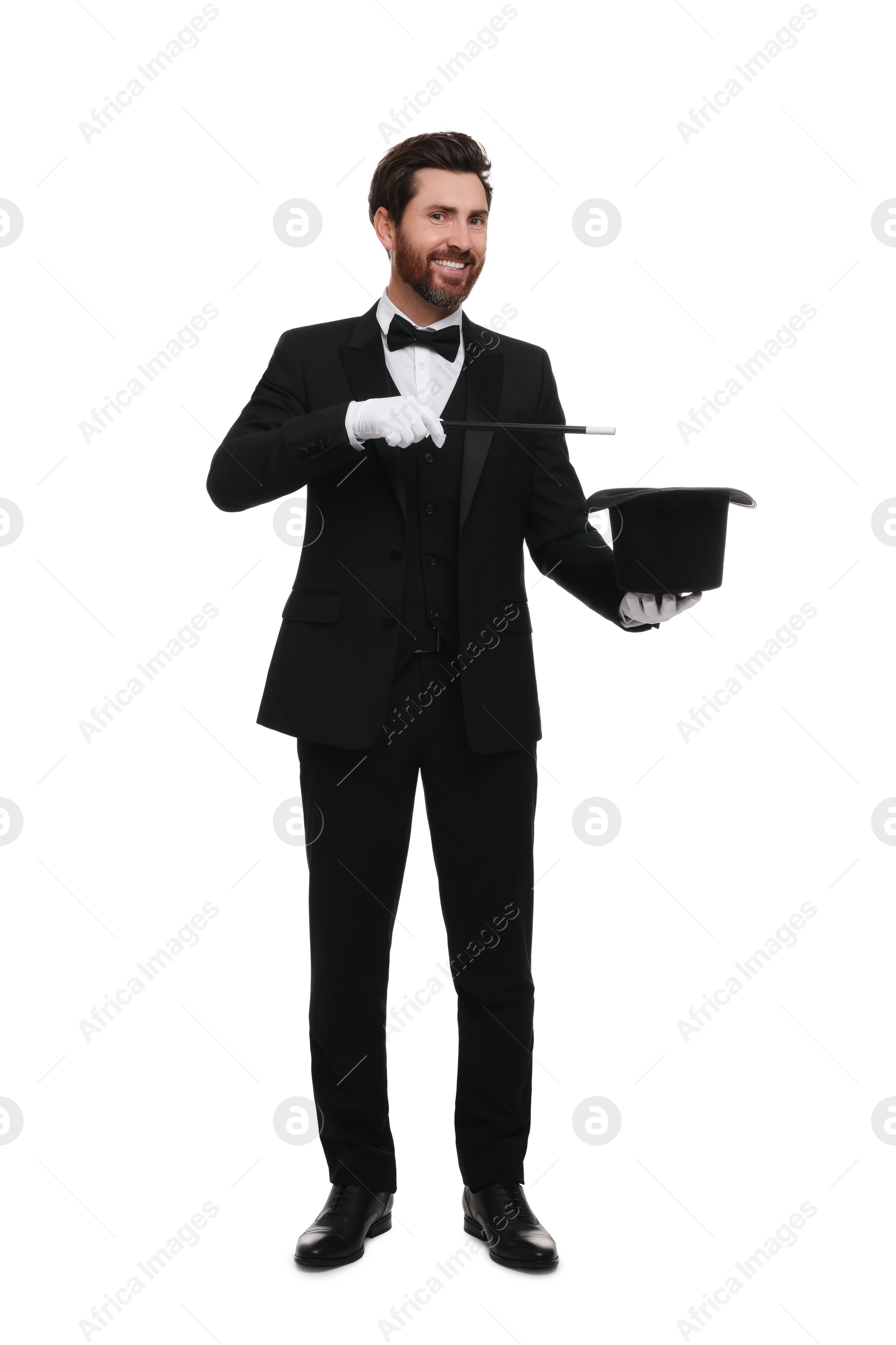 Photo of Happy magician showing magic trick with top hat on white background