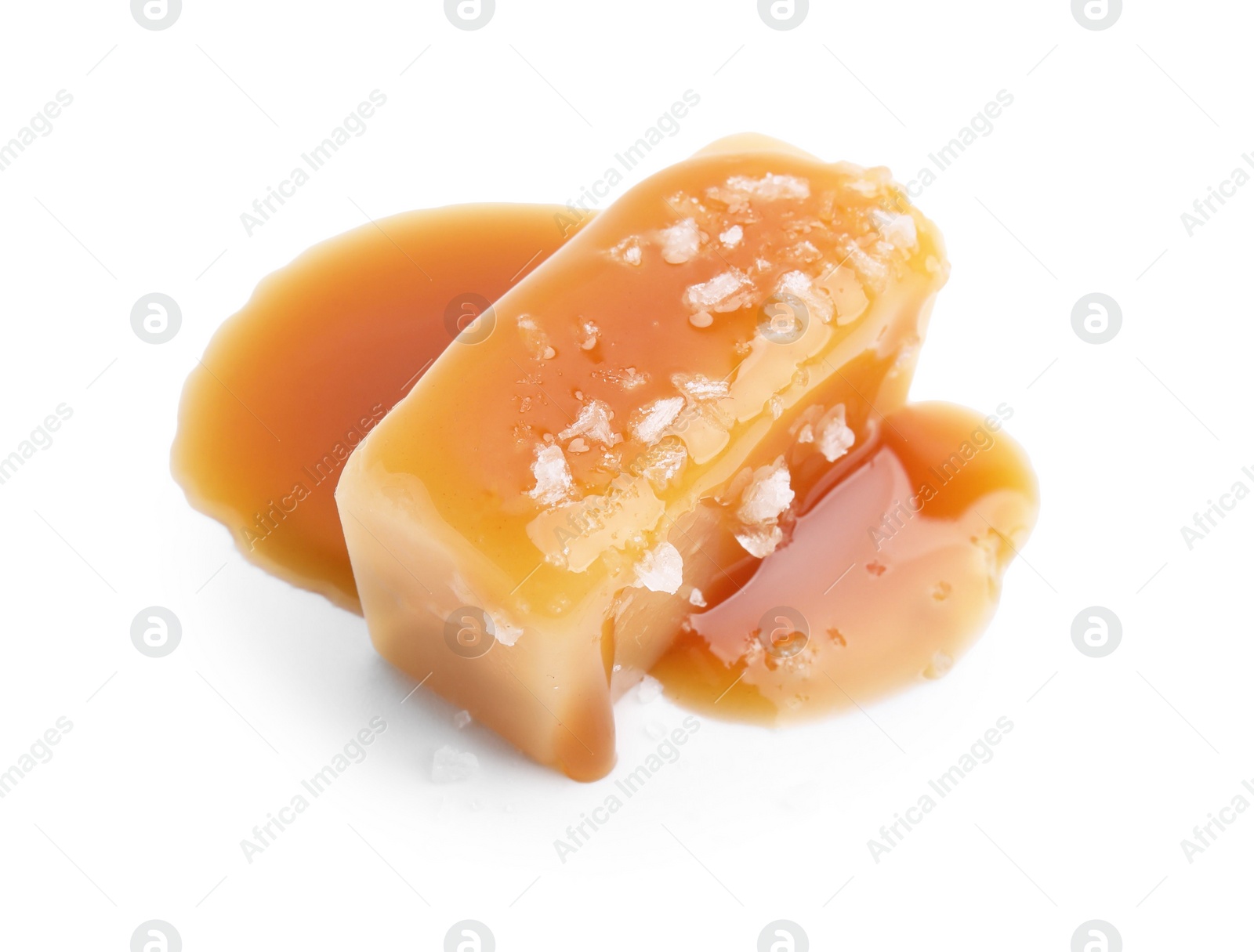 Photo of Yummy caramel candy and sea salt isolated on white