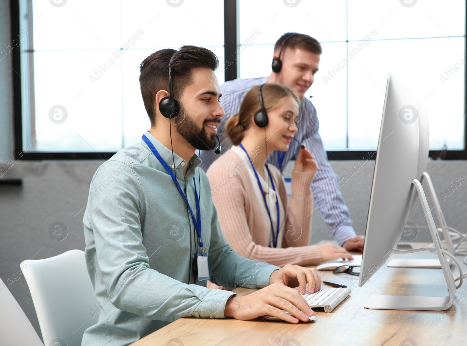 Photo of Technical support operator working with colleagues in office