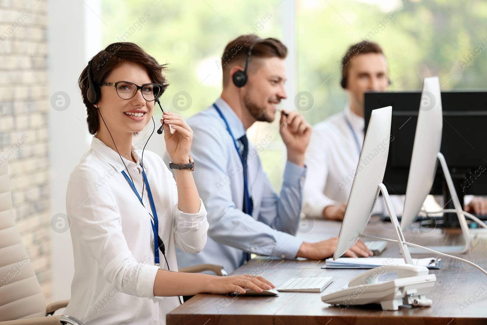 Photo of Technical support operators with headsets at workplace