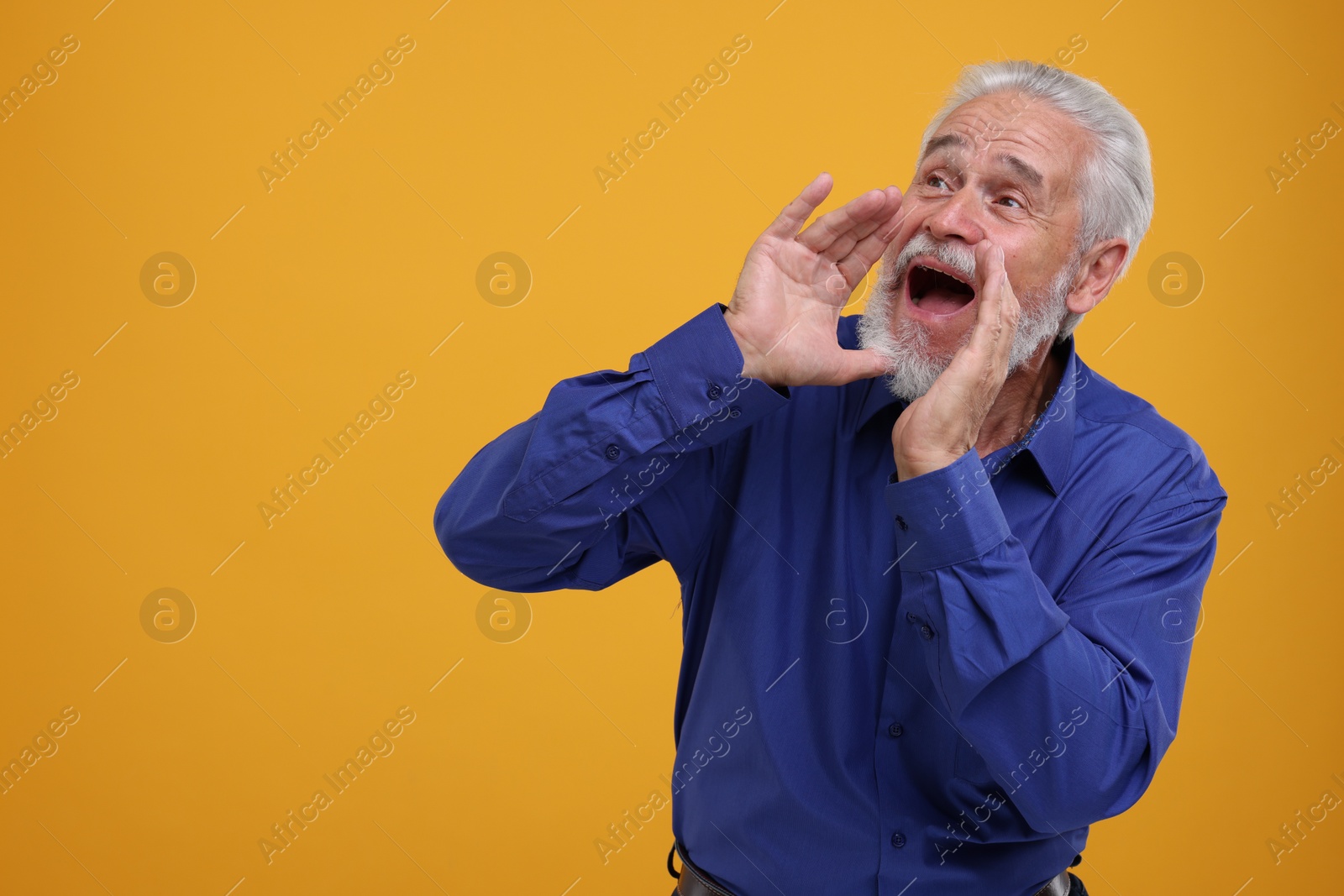 Photo of Special promotion. Senior man shouting to announce information on orange background. Space for text