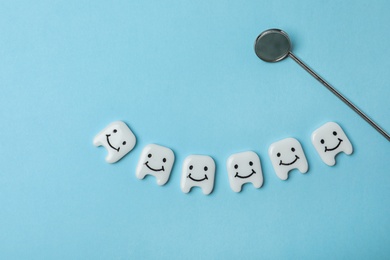 Photo of Flat lay composition with decorative teeth and dentist mirror on color background