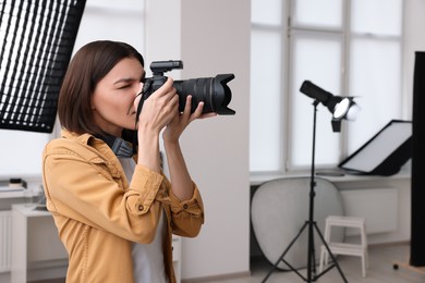 Photo of Professional photographer taking picture in modern photo studio