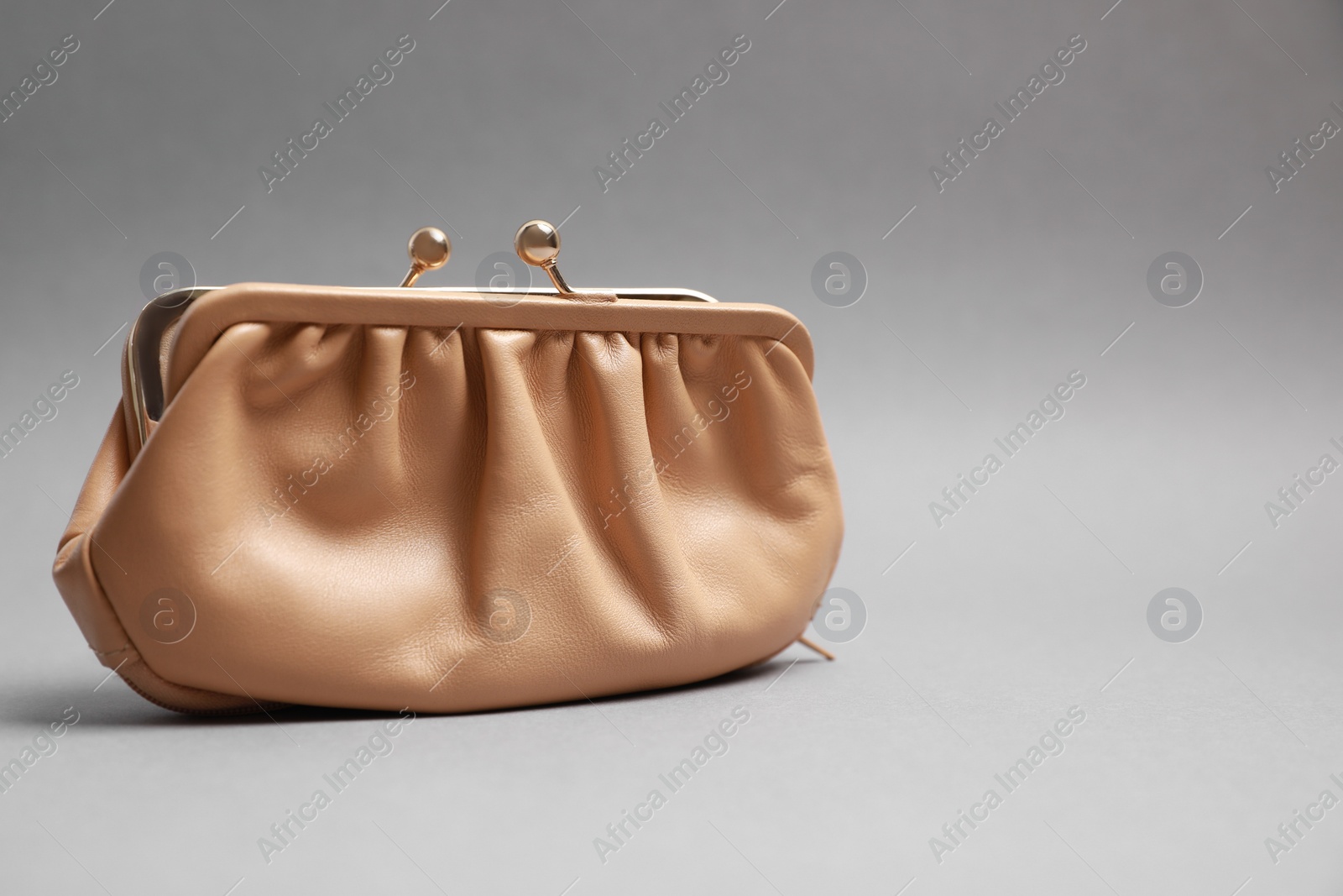 Photo of Stylish beige leather purse on light grey background. Space for text