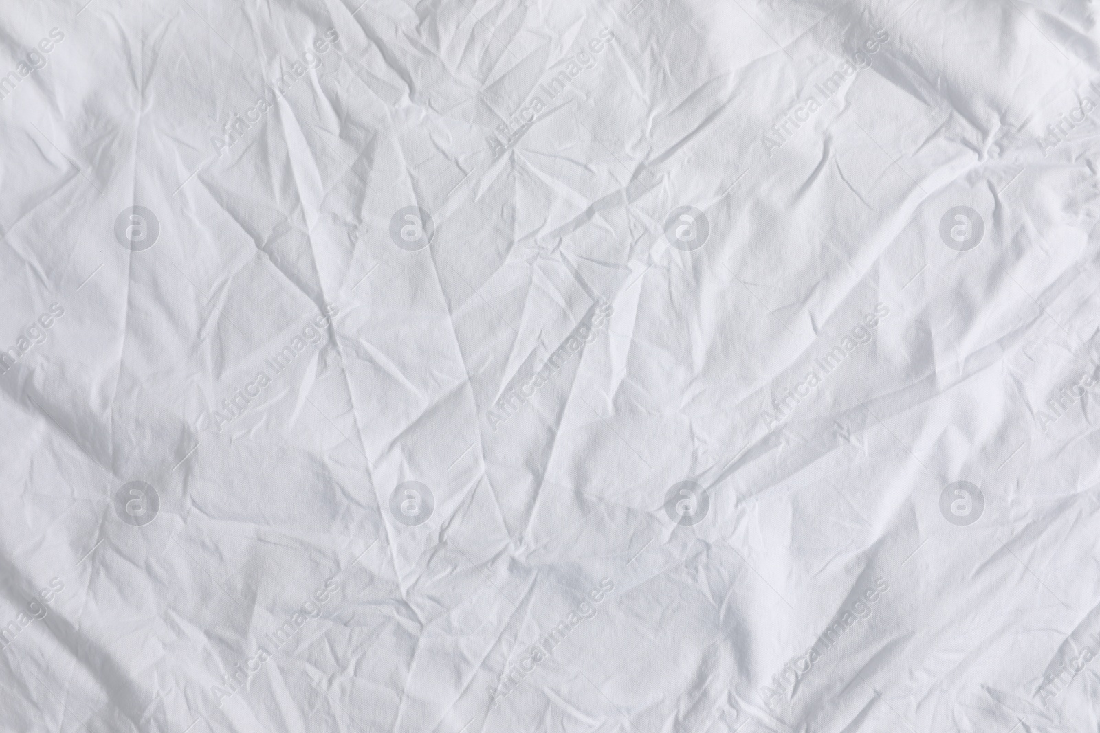 Photo of Crumpled white fabric as background, top view