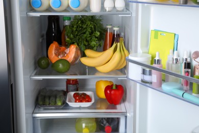 Photo of Storage of cosmetics in refrigerator door bin next to groceries