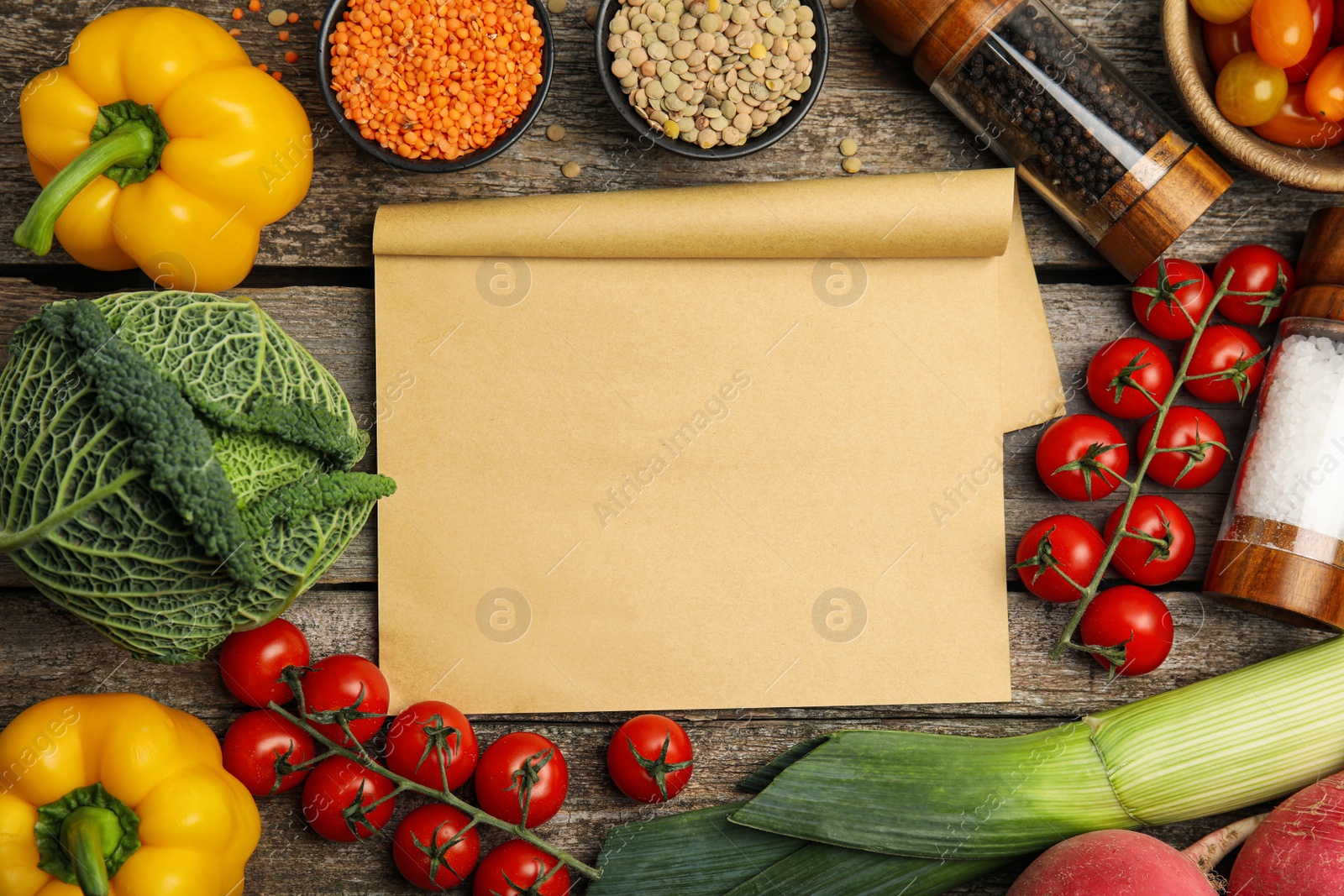 Photo of Recipe book surrounded by different ingredients on wooden table, flat lay with space for text. Cooking classes