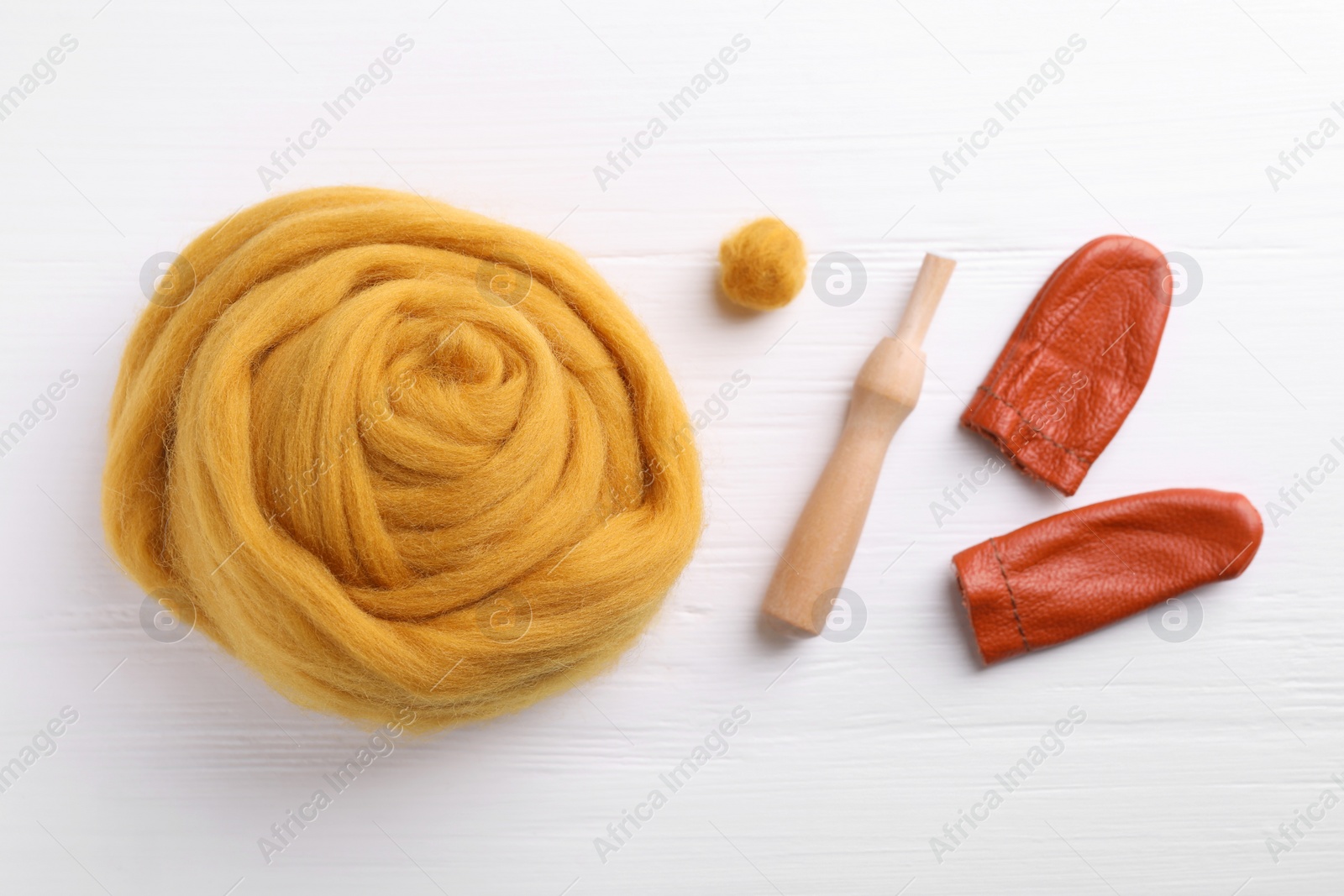 Photo of Flat lay composition with wool and needle felting tools on white wooden table