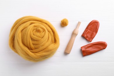 Photo of Flat lay composition with wool and needle felting tools on white wooden table